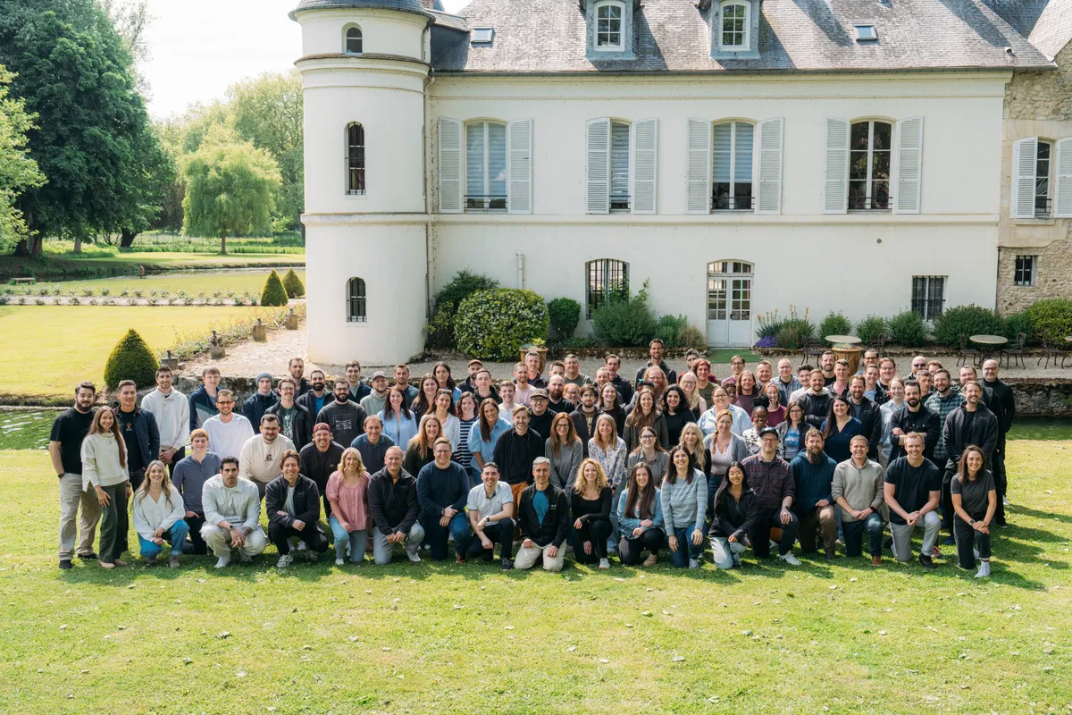 The Close team posing for a group photo on the lawn in front of a French château